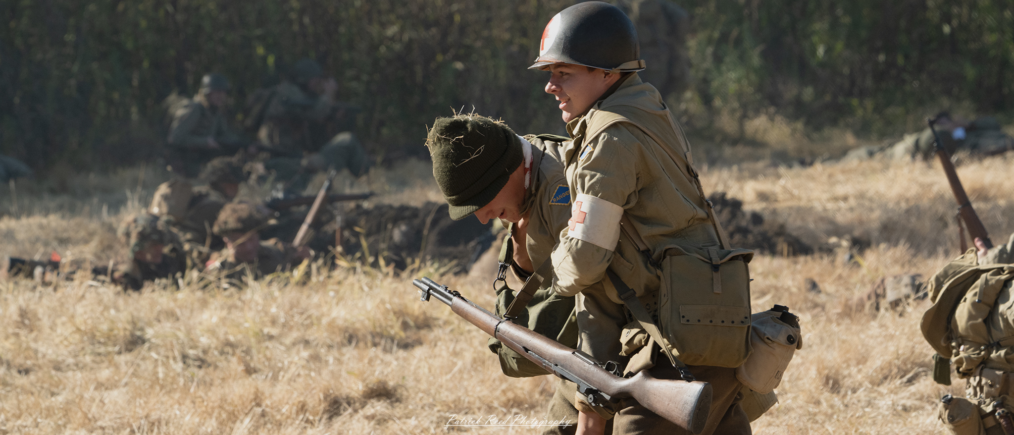 An American soldier struggling through a battlefield, carrying his wounded comrade on his shoulders. His face is set in determination despite the chaos around him, with explosions and smoke filling the air. The wounded soldier's arm hangs loosely, bloodied and limp, while the carrier's uniform is torn and smeared with dirt. Together, they push forward, embodying courage, sacrifice, and the unwavering bond between brothers-in-arms.